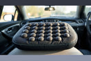 Massage cushion with multiple node zones placed on a car seat for comfortable support