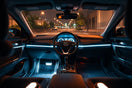 Car cabin at night with softly glowing LED strips along the dashboard and footwell