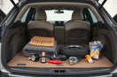 Neatly arranged automotive cleaning and safety gadgets on a car trunk mat