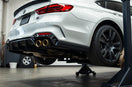 Modern sedan in a garage with performance exhaust, intake, and brake kit installed