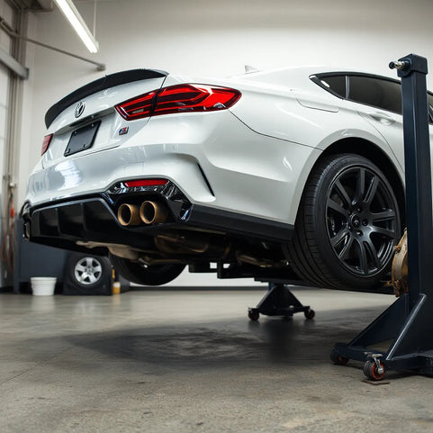 Modern sedan in a garage with performance exhaust, intake, and brake kit installed