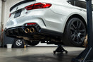 Modern sedan in a garage with performance exhaust, intake, and brake kit installed