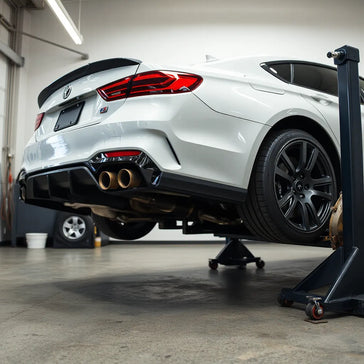 Modern sedan in a garage with performance exhaust, intake, and brake kit installed