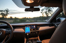 Modern car dashboard with a mounted smartphone and connected OBD-II diagnostic adapter