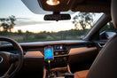 Modern car dashboard with a mounted smartphone and connected OBD-II diagnostic adapter