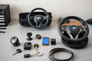 Assorted automotive accessories like a phone mount, dashboard camera, and steering wheel cover on a workbench