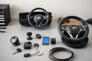 Assorted automotive accessories like a phone mount, dashboard camera, and steering wheel cover on a workbench