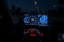Transparent heads-up display projects driving metrics onto the windshield in a modern car interior