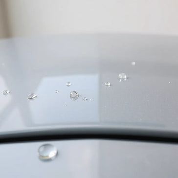 Water beads forming on a coated car hood surface under soft daylight