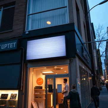 Bright dynamic LED signage on a storefront facade at dusk, glowing with subtle animated light patterns