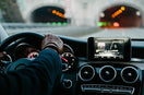 person inside vehicle holding steering wheel