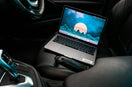 turned-on gray laptop computer placed on car bucket seat
