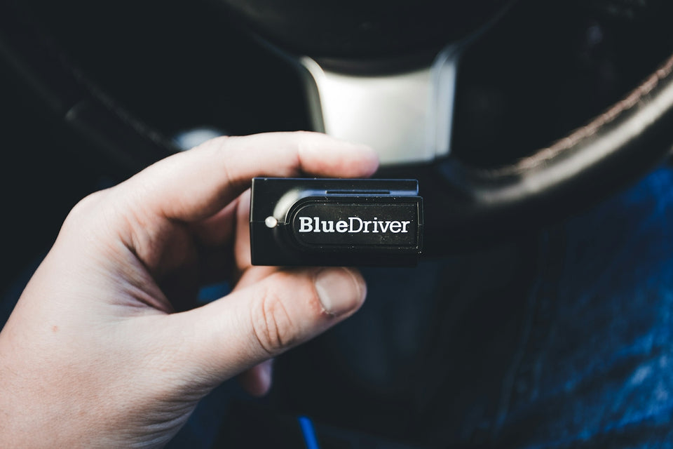a person holding a bluedriver in their hand
