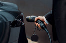 a man in a suit is pumping gas into a car