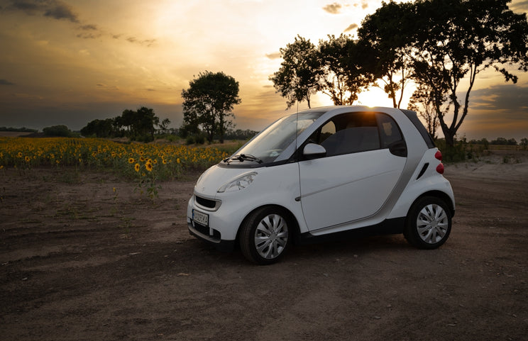 A smart car parked on a dirt road