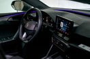 Modern car interior with illuminated dashboard and touchscreen.