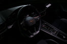 Dark car interior with a prominent steering wheel and controls