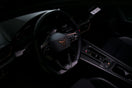 Dark car interior with a prominent steering wheel and controls
