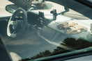 Modern car interior showing dashboard, steering wheel, and gloves